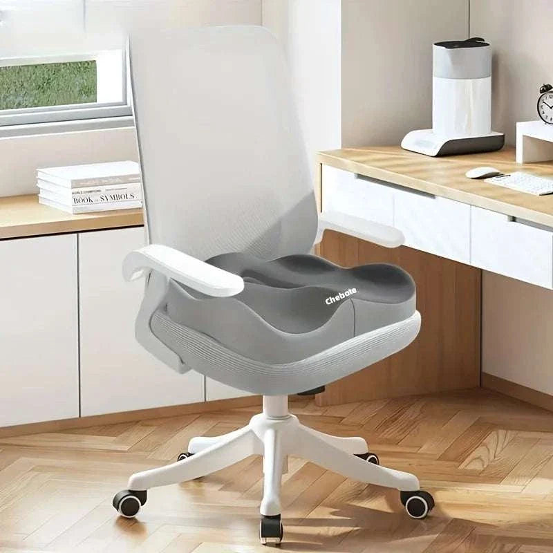 Gray memory foam seat cushion on white ergonomic office chair in modern workspace